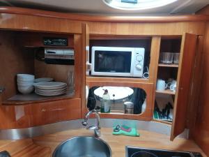 a kitchen with a sink and a microwave at Motoryacht ELENA in Eeklo