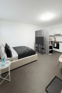 a bedroom with a large bed and a kitchen at Airport Apartment 64 in Freising in Freising