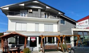 een wit gebouw met een zwart dak bij Hostel Mornar in Velika Kladuša