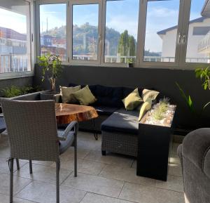 een woonkamer met een bank en een tafel bij Hostel Mornar in Velika Kladuša +7 foto's