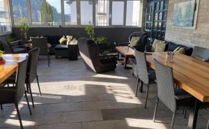 een restaurant met tafels, banken en stoelen bij Hostel Mornar in Velika Kladuša