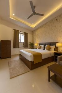 a bedroom with a large bed and a ceiling fan at Hotel Vrindavan Palace - A Luxury Stay with Parking near Prem Mandir City Center # By Om# in Vrindāvan