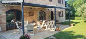 a patio with a table and chairs under a canopy at Casale Caldarette in Fermo