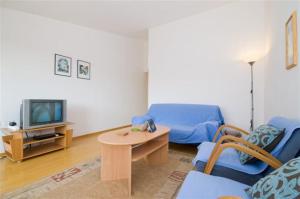 ein Wohnzimmer mit einem blauen Sofa und einem TV in der Unterkunft Villa Marianne in Vinkuran