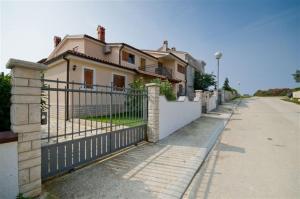 a house with a fence next to a street at Villa Marianne in Vinkuran