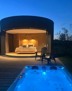 a master bedroom with a bed and a hot tub at Domaine de Chabrague in Amou