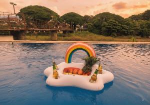 a float in the water with a rainbow and fruit at Intimate Riverside Resort in Vang Vieng
