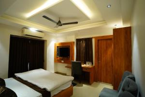 a bedroom with a bed and a desk with a computer at JRF Hotel in kolkata