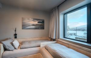 Cette chambre dispose d'un canapé et d'une grande fenêtre. dans l'établissement Staying Apt 5, à Tromsø