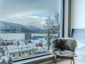 - une fenêtre avec vue sur une ville enneigée dans l'établissement Staying Apt 5, à Tromsø