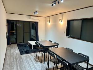a conference room with tables and chairs and a projection screen at Guest House YADOKARI in Hirakata