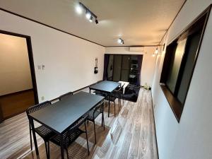 a room with two tables and chairs in a room at Guest House YADOKARI in Hirakata +6 photos