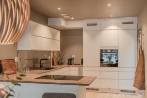 une cuisine avec des armoires blanches et un comptoir dans l'établissement Staying Apt 5, à Tromsø