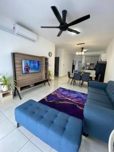 a living room with a blue couch and a flat screen tv at Alfie Homestay Bangi in Kajang