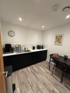 a kitchen with a counter and a table and a clock at New City Centre Apartment No 5 Free Parking in Leicester