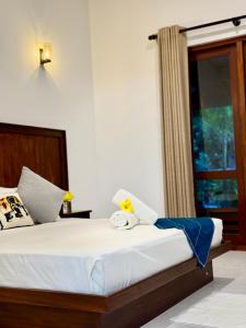 Un dormitorio con una cama grande con ventana. en Hiri Point Villa, en Dikwella 27 fotos más