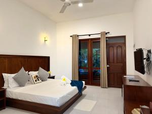 ディックウェラにあるHiri Point Villaのベッドとテレビのある寝室