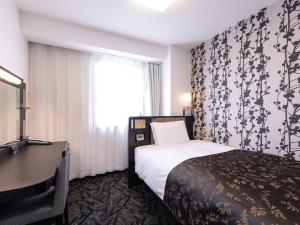 a hotel room with a bed and a desk and a window at APA Hotel Saga Ekimae Chuo in Saga +87 photos