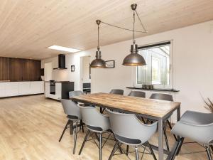 a kitchen and dining room with a wooden table and chairs at 8 person holiday home in Ålbæk-By Traum in Ålbæk