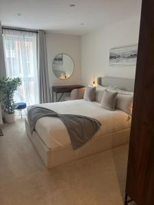 a bedroom with a large bed and a mirror at Entire Prestige Apartment in Poole Quay - Free Parking, Fast WiFi, Smart TV & Netflix in Poole