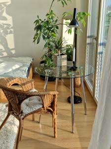 a glass table with a lamp and a chair in a room at Lumi, modernes Attika-Refugium in Derendingen