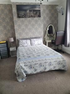a bedroom with a bed with a blue comforter at Private Double Room in Cardiff in Cardiff