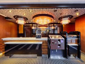 a lobby with a bar with chandeliers at APA Hotel Saga Ekimae Chuo in Saga
