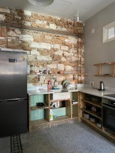 a kitchen with a refrigerator and a stone wall at Loutra Edipsou Serenity Suites in Loutra Edipsou +32 photos