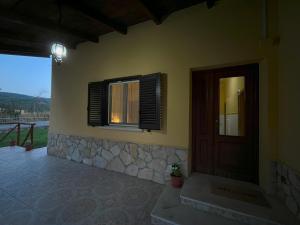 a house with a window and a door and a porch at Guzzolini Camere & Relax in Camigliatello Silano