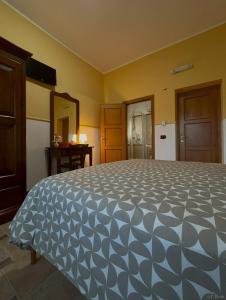 a bedroom with a large bed with a blue and white comforter at Guzzolini Camere & Relax in Camigliatello Silano
