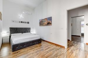 a bedroom with a bed in a white room at StarHome Colosseo in Rome