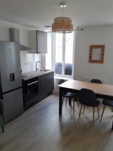 a kitchen with a wooden table and a dining room at Appart centre FNAC in Le Mans