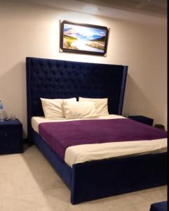 a bedroom with a large bed with a black headboard at Grand Arham Hotel Faizabad in Rawalpindi +10 photos