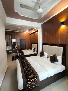 En eller flere senge i et værelse på Hotel Aashray