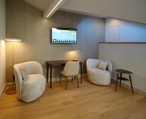 a room with two chairs and a table and a screen at Villa Patriot Boutique Hotel in Mariánské Lázně