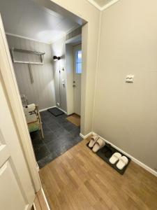 Un pasillo con dos pares de sandalias en el suelo. en Stranda Apartment, en Senja 35 fotos más