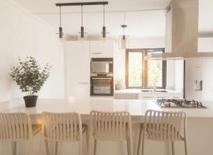 a kitchen with a island with chairs and a counter top at Villa JULIE, Plages de Belle Mare à 10 minutes in Post of Flacq