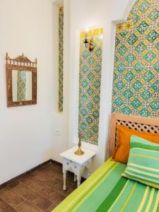 a bedroom with a bed and a mirror on the wall at La Maison de haut in Tunis