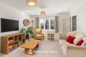 Una sala de estar con un sofá y un televisor. en Pass the Keys Spacious Modern Family Home - 20 mins to Oxford, en Garford