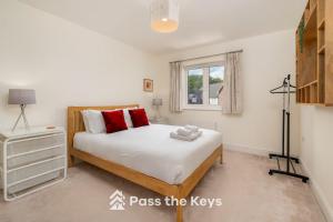 un dormitorio con una cama y una ventana en Pass the Keys Spacious Modern Family Home - 20 mins to Oxford, en Garford