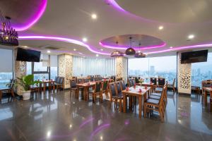 a restaurant with tables and chairs and purple lighting at GOLDEN SUN DANANG Hotel in Da Nang +32 photos
