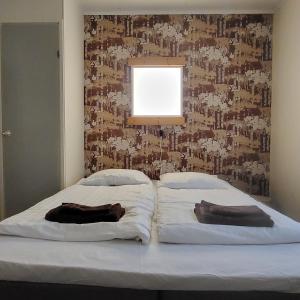 1 cama con 2 almohadas en un dormitorio con pared en B&B RukaTupa, en Ruka