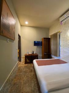 a hotel room with a bed and a television at Puunee Wild River Villa's Borobudur in Borobudur