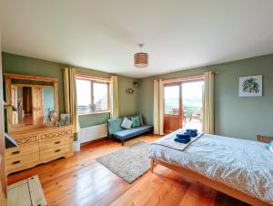a bedroom with a bed and a chair and a mirror at Fern Lodge. Drumcoura Lake Resort, in Ballinamore
