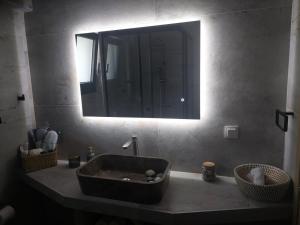 un lavandino del bagno con un grande specchio sopra di Theros a Nikiana Altre 21 foto
