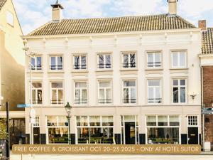 布雷达苏特尔酒店的街道上一栋有窗户的白色大楼