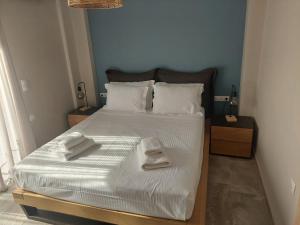 una camera da letto con un letto con due asciugamani sopra di Theros a Nikiana