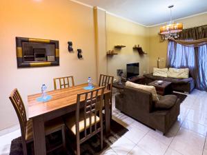 a living room with a table and a couch at 98. Homey 2BR Townhouse 2 Queen Beds Garden in Sheikh Zayed