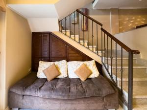 a living room with a couch under a staircase at Cozy Townhouse, with back yard (98) in Sheikh Zayed