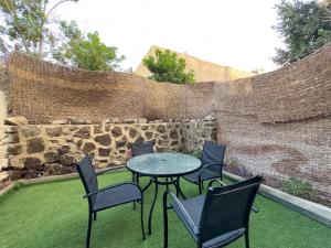 a patio with chairs and a table and a stone wall at Cozy Townhouse, with back yard (98) in Sheikh Zayed
